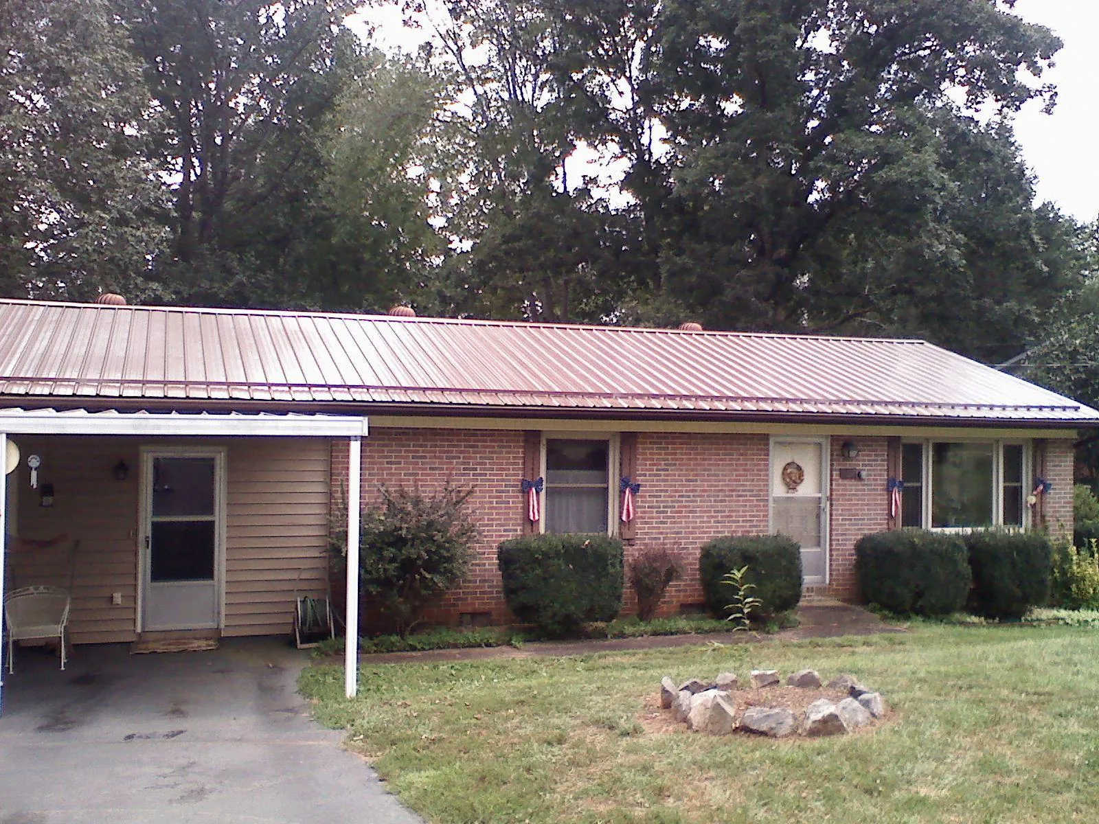 Bronze metal roof and carport on a brick ranch home — Roof Repair work by our crew in Mabton